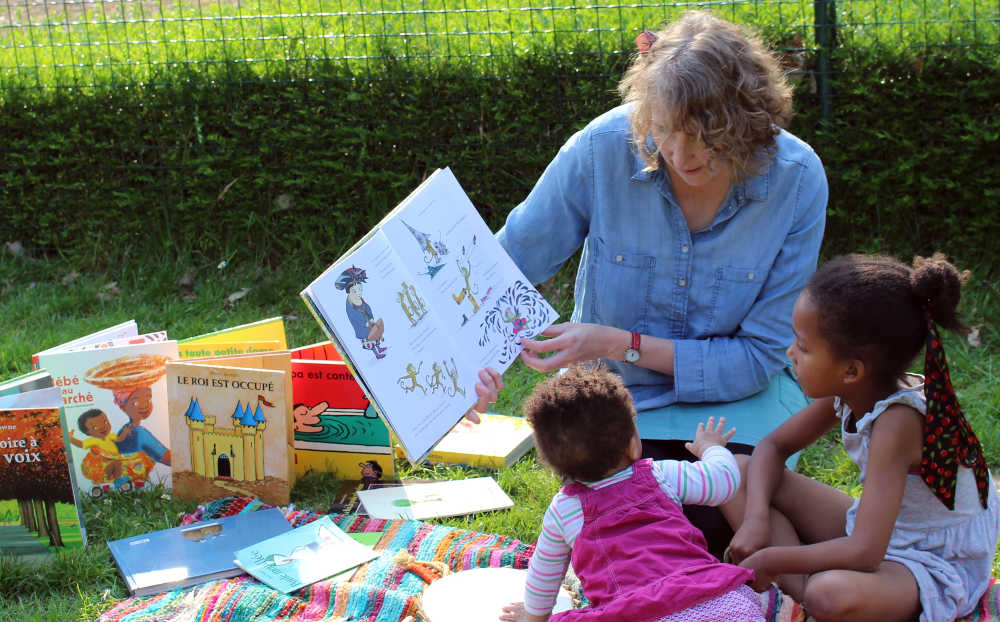 Enfants écoutant la conteuse et regardant le livre