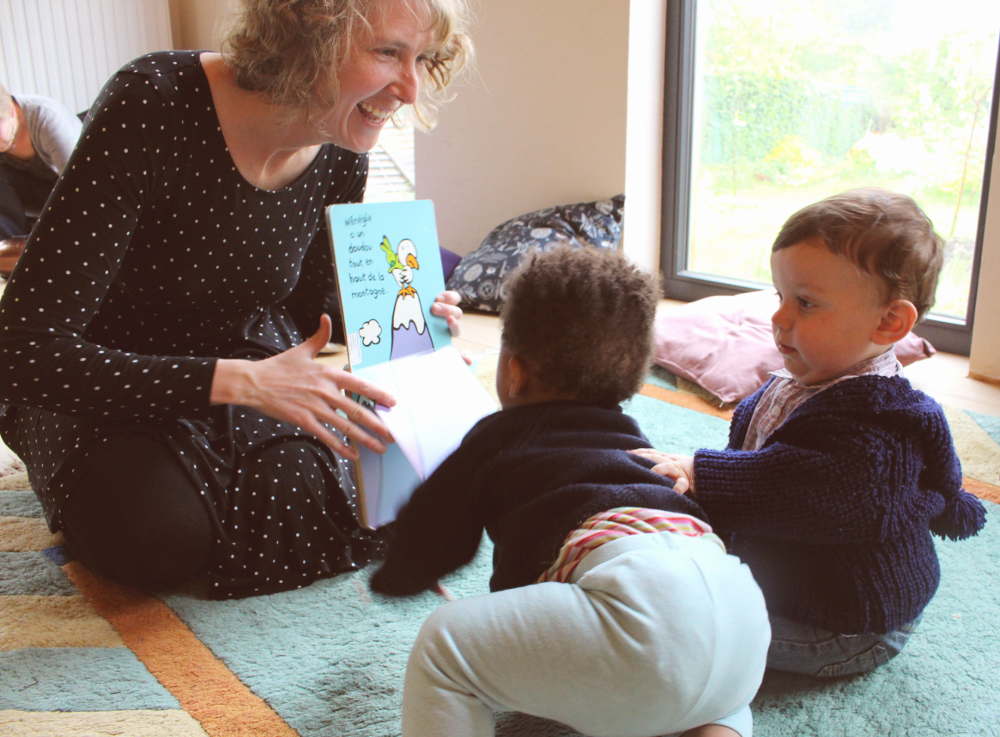 Enfants écoutant la conteuse et regardant le livre